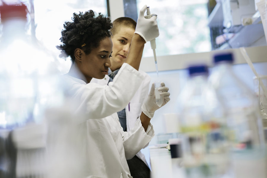 Female Scientists Pipetting In A Laboratory