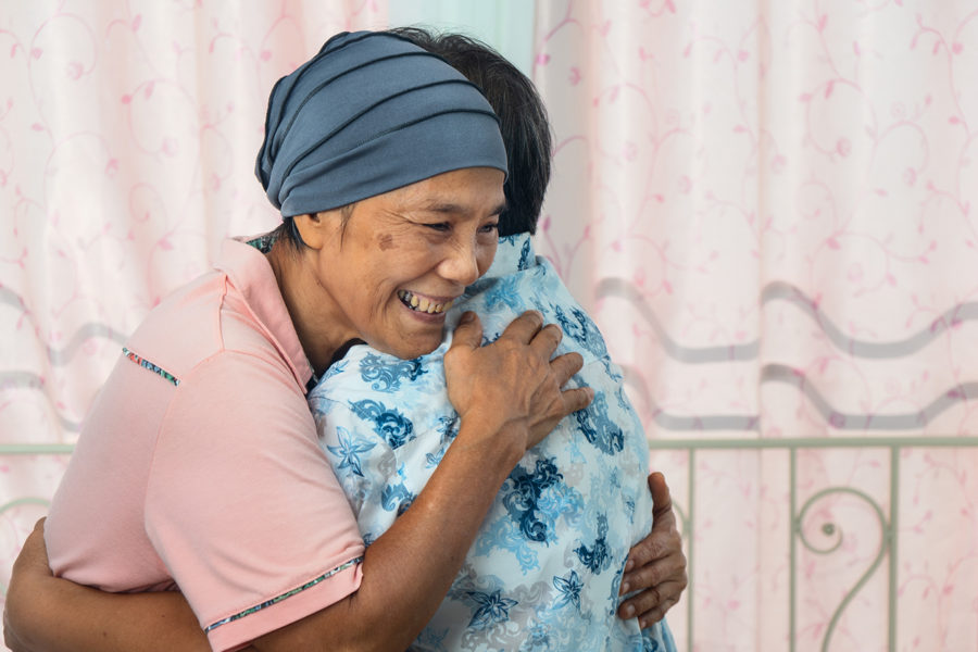 asian female cancer patient with headscraf look happy have a hug