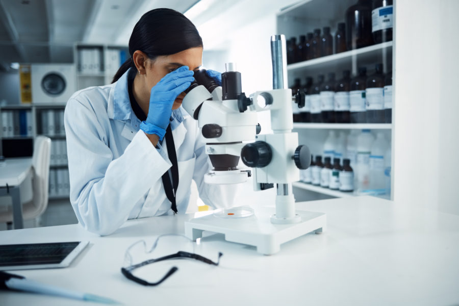 Ill Find You And Ill Fix You. Shot Of A Young Scientist Using A Microscope In A Laboratory.